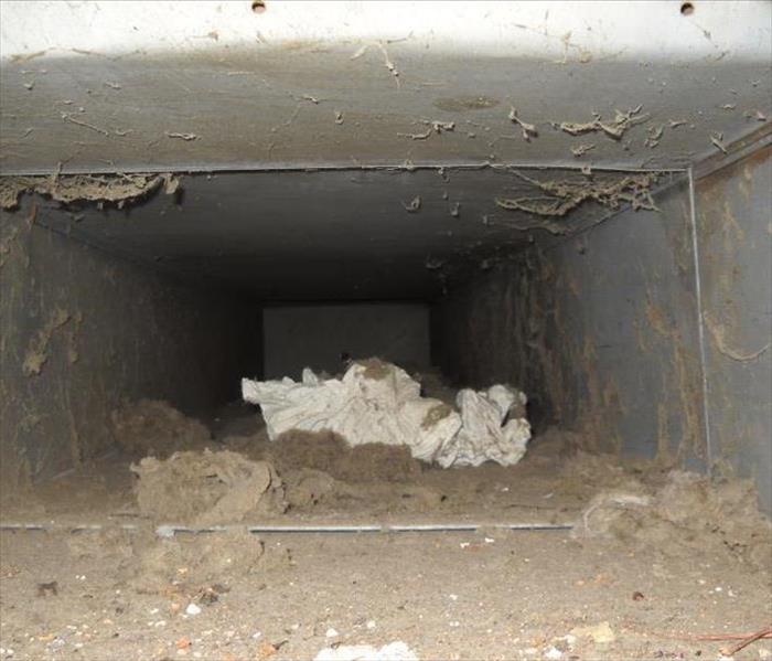 A photo of an air duct with a lot of dust and debri