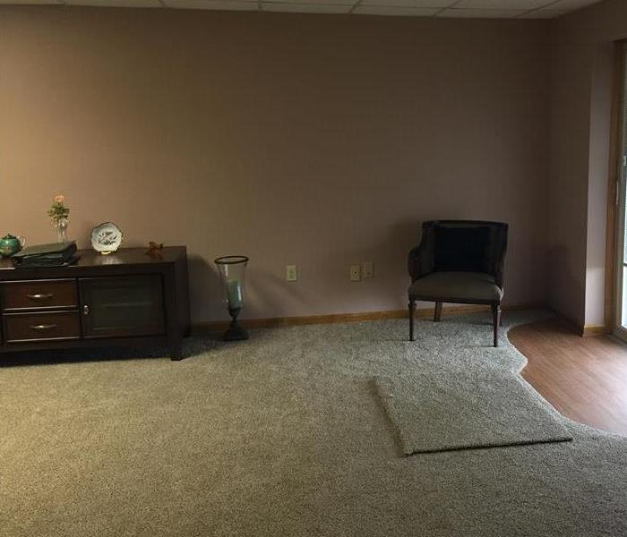 New carpet and walls with homeowners chair and dresser