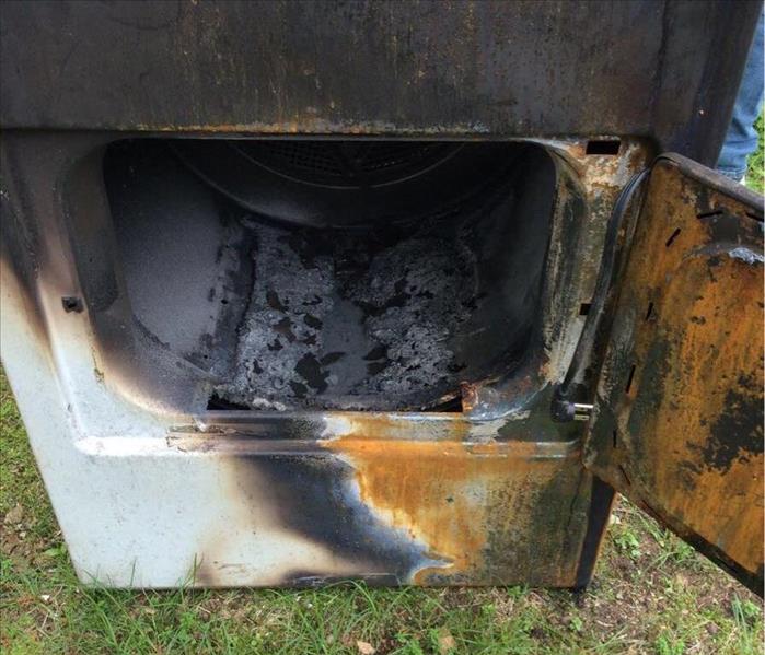 A photo of a dryer that is damaged by a fire