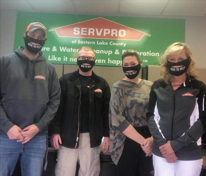 4 employees in front of SERVPRO sign all wearing here to help masks